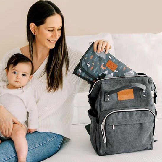 Sac a langer gris avec maman et bébé assis sur le lit