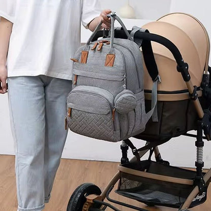 Sac a langer gris pâle attaché à une poussette avec maman