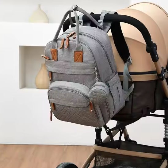 Sac a langer gris pâle attaché à une poussette