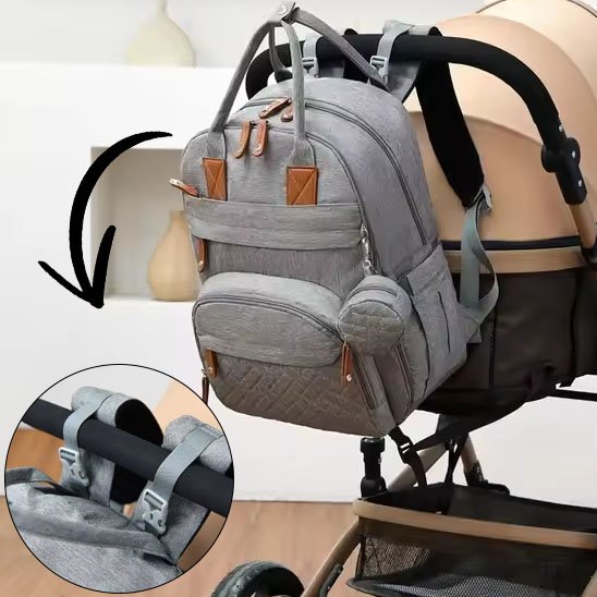 Sac a langer gris pâle attaché avec sangles à une poussette