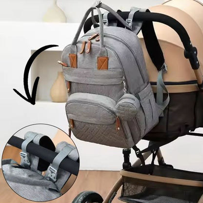 Sac a langer gris pâle attaché avec sangles à une poussette