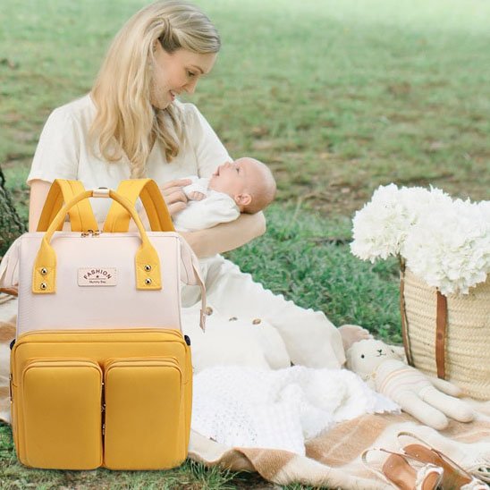 Sac a langer jaune et beige avec maman et bébé en campagne