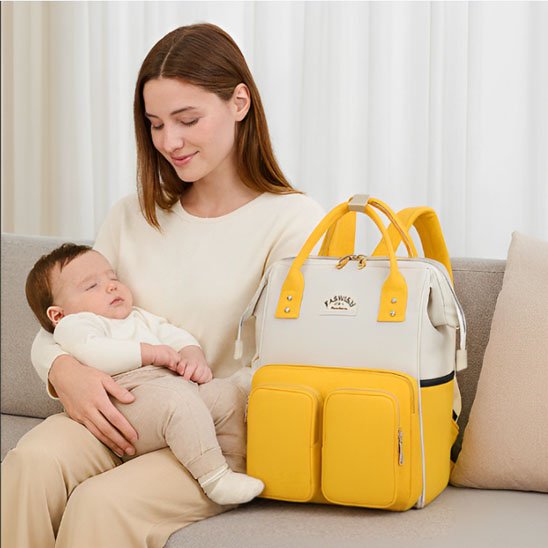 Sac a langer jaune et beige avec maman et bébé qui dort