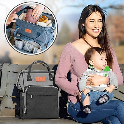 Sac a langer noir et gris avec maman assise sur un banc et tenant bébé
