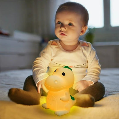Veilleuse bébé dinosaure sur le lit avec bébé