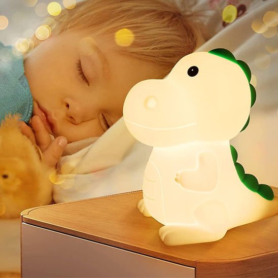 Veilleuse bébé dinosaure sur table avec enfant qui dort
