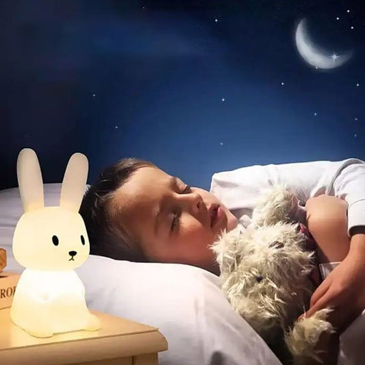 Veilleuse bébé lapin sur table avec enfant qui dort dans son lit
