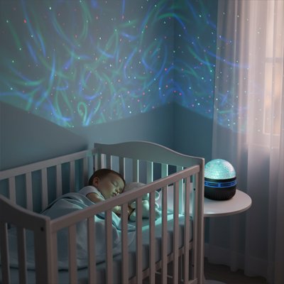 Veilleuse projection sur table avec bébé qui dort dans son lit